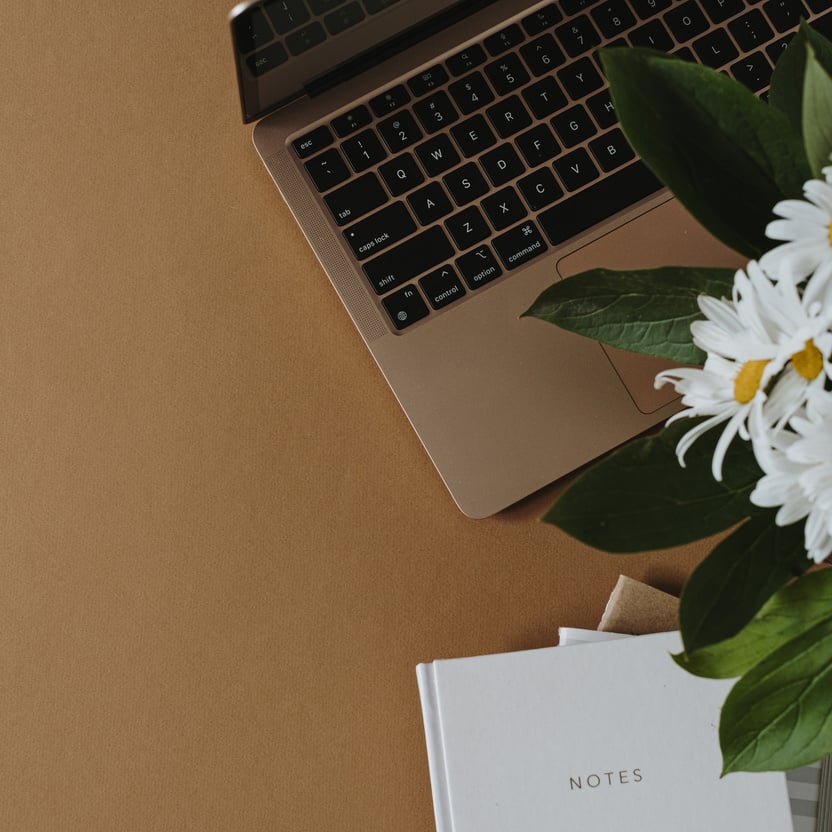 Laptop with Notebook and Bouquet of Flowers 