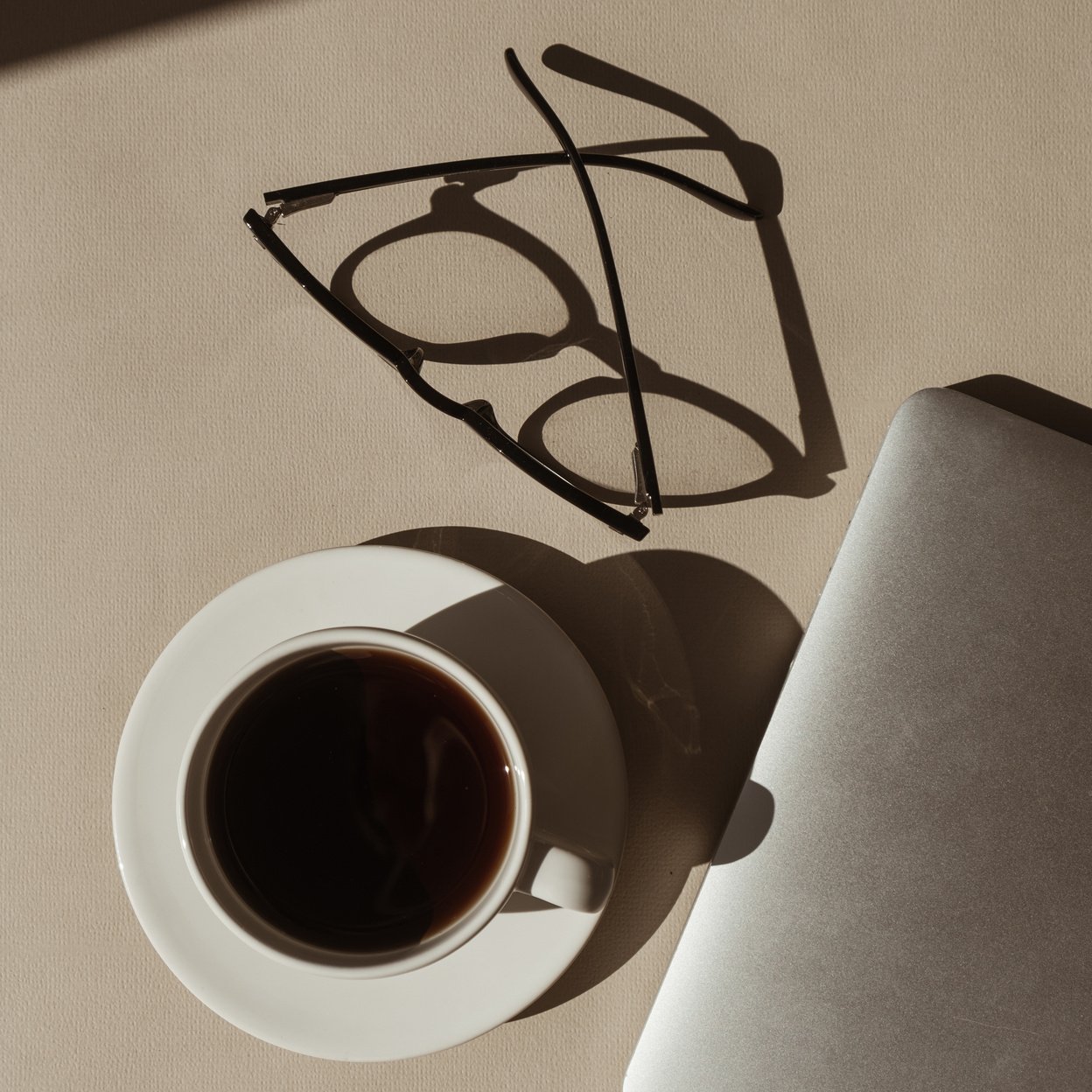 Cup of Coffee, Laptop, and Eyeglasses on Workspace 