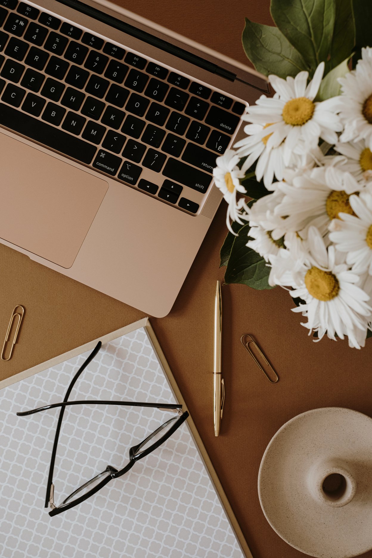 Laptop and Bouquet of Flowers on Brown Background